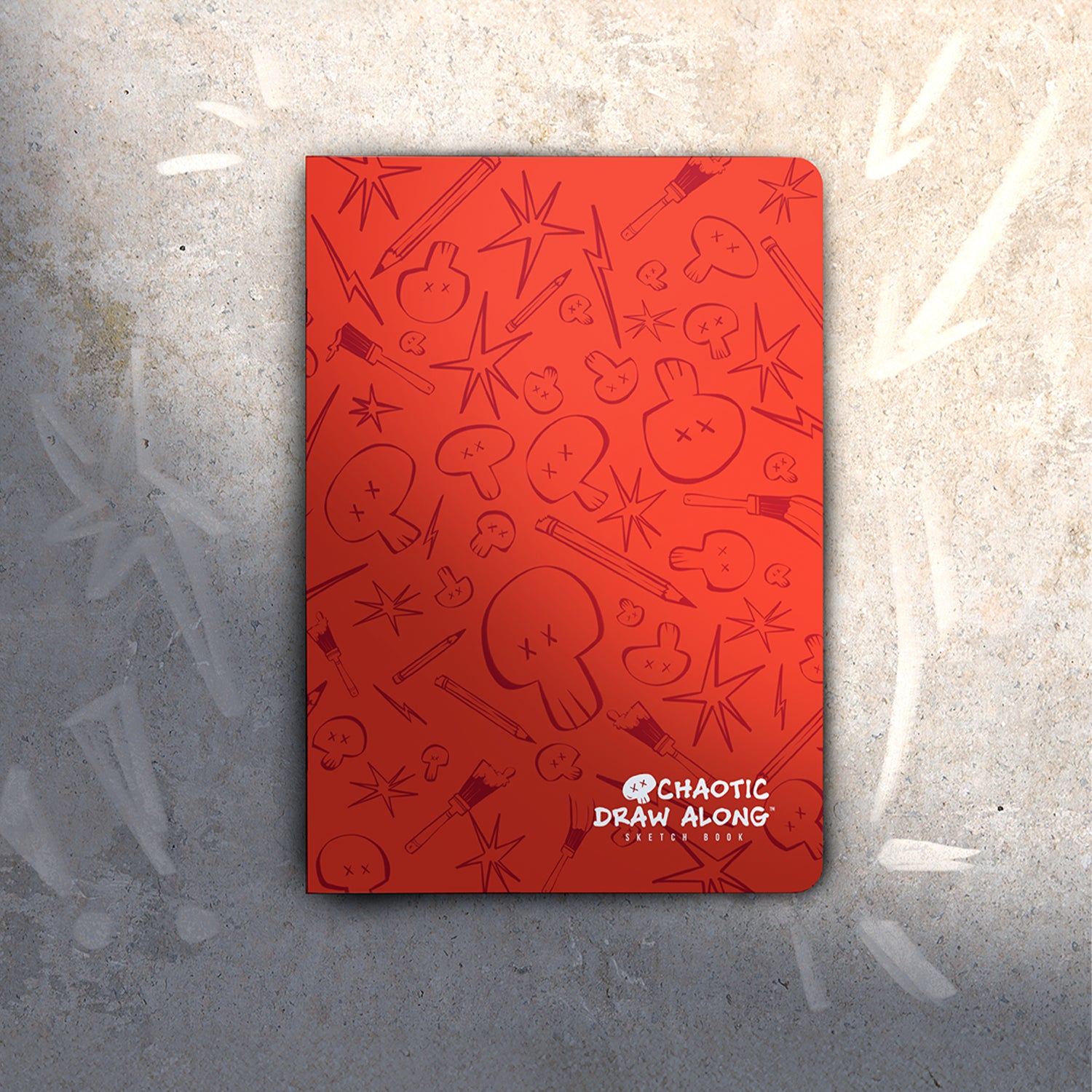 Chaotic Draw Along red sketchbook on textured concrete with chalk arrows and exclamation marks, creating a bold, street-style vibe
